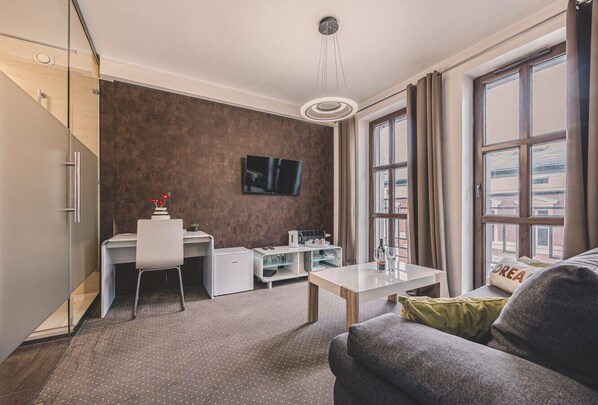 A modern living room with comfortable sofas, a TV, and large windows. Close to the Old Market Square, Opera Nova, and the Old Town. Perfect for both business and leisure stays!