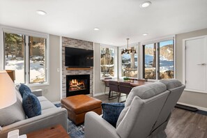 Witness every season in this cozy bright living room with modern decor, just steps from the pool and hot tub area