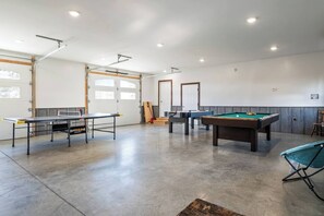 Challenge your friends and family in this spacious game room, featuring a pool table and air hockey for endless entertainment. Perfect for rainy days or late-night fun! 