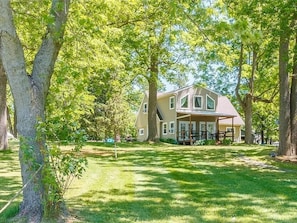 Enjoy the privacy of this beautiful home surrounded by mature trees, offering a tranquil setting just steps from the lake. A nature lover’s paradise! This is the second home off the water. "Land House"