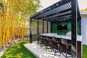 Grill night awaits under the pergola at the outdoor kitchen. Watch the game on the TV and spread out with bar top seating for 8.