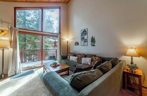 Living room with large sectional sofa overlooking the majestic pine trees.