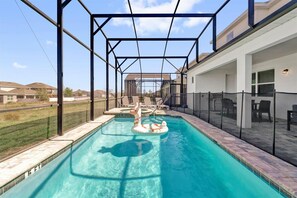 Enjoy your private oasis with a sunlit pool and relaxing patio, perfect for family fun and unwinding under the clear skies.