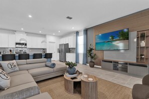 Relax in this modern living room with a sleek open kitchen, perfect for entertaining and unwinding.