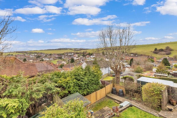 Scenic balcony view overlooking lush greenery and a charming countryside landscape
