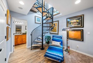 Versatile lower-level living & sleeping area featuring a wind-down staircase