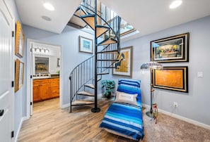 Versatile lower-level living & sleeping area featuring a wind-down staircase