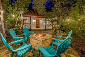 Cozy backyard retreat with string lights, a fire pit, and comfortable seating.