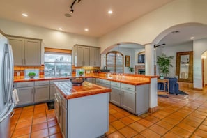 Spacious kitchen with a large island and seating, ideal for enjoying morning coffee or group meal prep.
