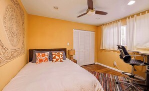 Queen bedroom with a dedicated workspace and ceiling fan​