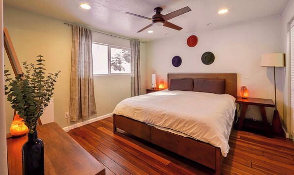 Luxurious king ensuite featuring a spacious bed, stylish décor with ceiling fan​