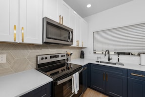 Functional kitchen with oven, stove, fridge and basic cooking ware