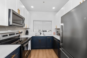 Functional kitchen with oven, stove, fridge and basic cooking ware