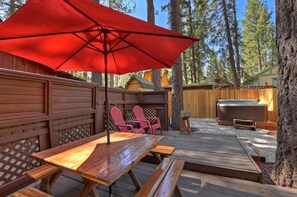Back patio area of the cabin has an outside dining area and hot tub. fully equipped place