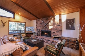 The cabin has a comfy living room with a HDTV, Forrest views, and deck access. (Fireplace not currently functioning)