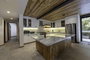 Large island with wireless charging stations, pop-up power outlets, and bluetooth speakers.