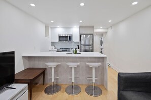 This sleek kitchen setup features a spacious island with modern stools—perfect for everything from breakfast to evening chats