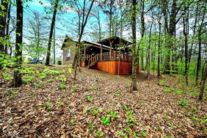 This cabin retreat sits on a hill above a private pond, on an acre lot.