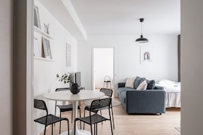 Apartment dining area and living room. There is one bed in the living room and a bed sofa.