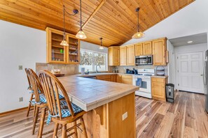 Kitchen: Keurig, drip coffee maker, cooking utensils, tableware, wine glasses, toaster, cutting boards, and knives
