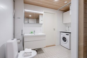 Apartment bathroom includes a private sauna and a washing machine.
