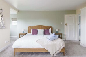 Bright and cosy king bedroom with soft, pastel tones and garden views.