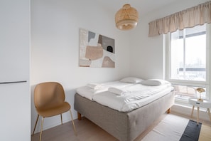 Apartment guest bedroom includes a 140cm wide bed and a small closet.