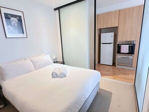 The master bedroom with a queen sized bed & plush pillows.
