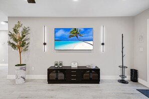 A sleek and inviting living area with a large TV, modern furniture, and vibrant lighting. Perfect for cozy nights in or entertaining guests.