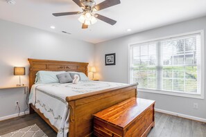 Sleep in comfort with a cozy bed, warm wood furnishings, and bright natural light.
