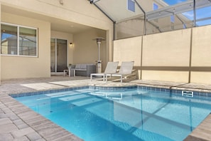 Enjoy A Refreshing Swim In This Screened-In Pool Area