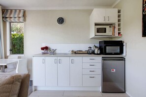 The kitchenette has a portable cooktop, bench oven, microwave, mini fridge and a larger fridge/freezer in the bathroom.