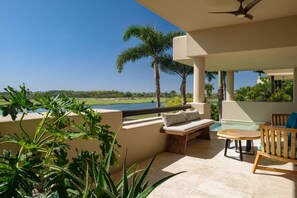 A terrace with a living area, pool, and views.