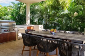 Outdoor dining area with an equipped BBQ grill and views.