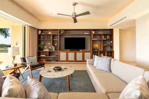 Living room with sofa and TV, near the kitchen.