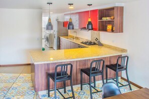 Open kitchen with a big counter and 3 high chairs. Great for entertaining the chef or using as a work station.