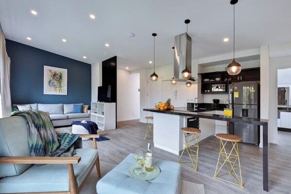 Open kitchen and living room. Bar doubles as dining table. 