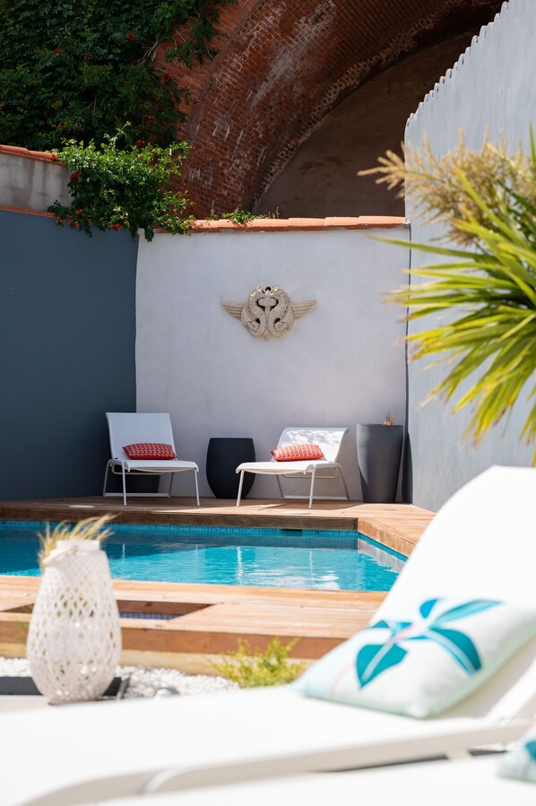 Vue d’ensemble de l’espace piscine, ambiance paisible et coin chill pour vos moments de détente.