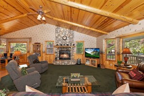 Relax in our rustic living room with a stone fireplace and comfortable seating
