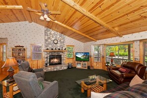 Relax in our rustic living room with a stone fireplace and comfortable seating