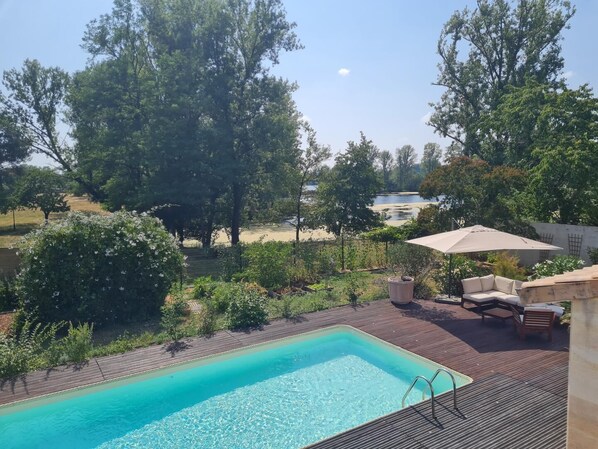 vue d'ensemble de la piscine et du salon de jardin au sein d'un jardin paysager