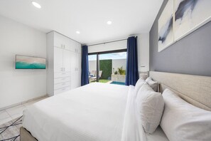 A peaceful bedroom retreat with a comfy king-size bed and a view of the private pool outside, perfect for unwinding after a long day.
