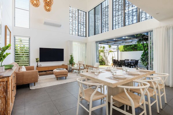 The main living room features raked ceilings, a slow-combustion fireplace, and sliding doors that open fully to create seamless indoor-outdoor flow.