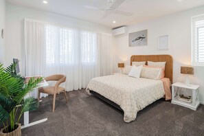 Bedroom two is spacious and stylish with a queen bed, mirrored wardrobes, and an ergonomic workspace.