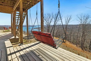 On the lower level of our deck, enjoy a hanging porch swing and another dining table.