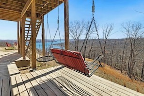 On the lower level of our deck, enjoy a hanging porch swing and another dining table.