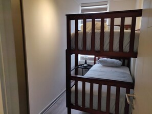 Cozy bunk bed setup perfect for kids or extra guests, featuring natural light and simple decor for a restful stay.