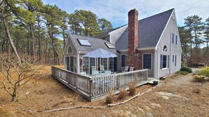 Deck off sunroom with outdoor furniture and wooded view