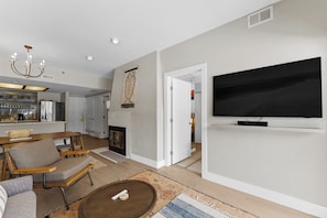 Living area featuring a flat-screen TV, queen sleeper sofa, and access to the private balcony.