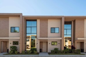 Modern townhouse with large windows, sleek facade, and peaceful neighborhood vibe.
